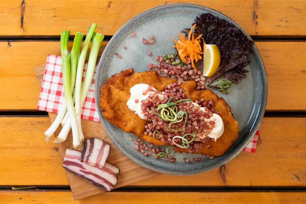 Schnitzel mit Sauerrahm, gebratenen Speckwürfeln und Lauchzwiebeln