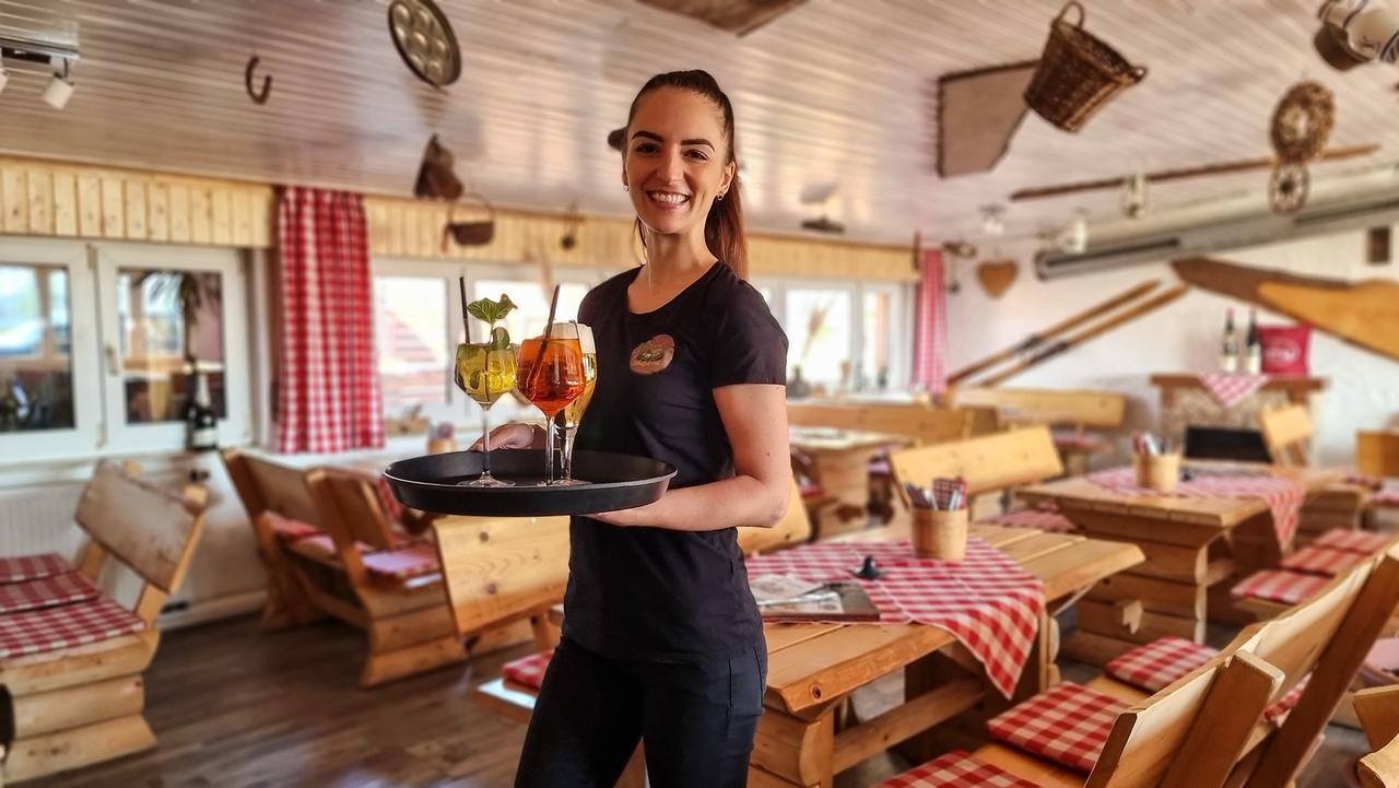 Servicekraft der Schnitzel-Hütte hinter dem Tresen